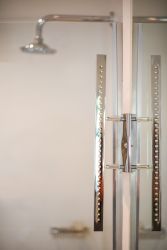 Patio Self-Catering Suite, en suite bathroom with shower and mirror light creating reflection