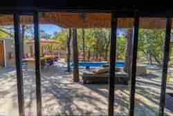 Sky Villa - Bedroom 1 Ensuite - The scenic view from the sitting area in the bedroom of the pool and garden.