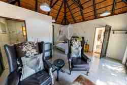 Sky Villa - Bedroom 1 Ensuite -  The comfortable  sitting area with a scenic view of the pool and bush. Put your feet up and enjoy a good book! Maybe you'll see some of the wild animals (kudu, zebra, wildebeest, buck) roaming past!