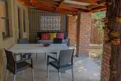 Remington Villa - The outside under-roof dining area with a scenic view of the pool and bush. At Remington Villa, it's all about outdoor living!