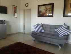 Sitting room with fold-out sofa to a double bed, TV, WiFi, microwave, bar fridge and kettle