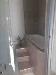 Elevated bathtub. The entire bathroom has slip resistant tiling, for added safety.