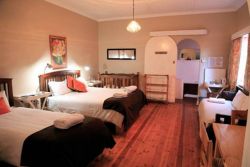 Room nr 5 with a queen size bed and a single bed, sleeper couch and cot. 