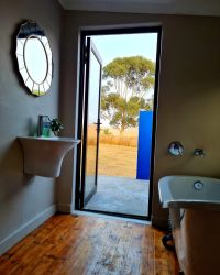 The ensuite bathroom has a door leading onto an outdoor shower to enjoy in summer.