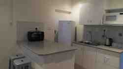 Self-service kitchen has a microwave oven, a mini-stove with oven, fridge and tea and coffee making facilities.