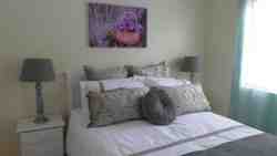 A double bed and a single bed occupy this spacious north facing bedroom, which has ample built-in-cupboards, dressing table (or desk), a hairdryer and an electric fan.