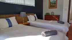 Bottom bedroom with two single beds that can be pushed together to make a king. 