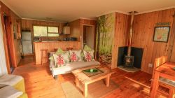The Cabin has a small open plan lounge. Relax on the couch while enjoying the views out of the sliding door. Or watch a movie on Netflix, while cuddled up with a roaring fire.
