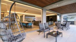 Outdoor patio with hanging chairs and dining table sea views