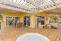 Patio with full sea views and jacuzzi and outside seating arrangement and two dining tables and braai