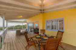 Patio with full sea views and jacuzzi and outside seating arrangement and two dining tables and braai
