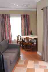 The spacious lounge/dining area has a lovely view of pool and garden