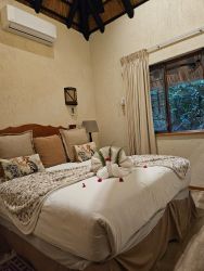 Second bedroom with queen bed. Airconditioner, ceiling fan and bathroom with shower, toilet and basin.