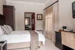 Carpted pool-facing Luxury Room with double bed and full ensuite. Ceiling Fan and Mini bar-fridge. No Aircon.