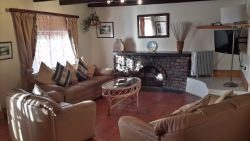 Birdsong lounge with open fireplace and premium menu flat screen DSTV and DVD player