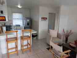 Modern fully equipped kitchen with front loader washing machine, fridge freezer, stove/oven and microwave.