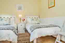 Second bedroom with single beds and garden view.