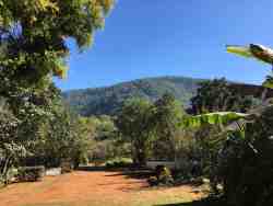 Main parking area, with a partial view of the mountain. Parking leading down from main building towards on-site mini dam.
