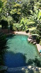Solar heated swimming pool with top spa pool and children's slide into the pool