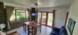 Cottage 2 - living area, woth double sleeper couch. Lovely view over swimming pool and river