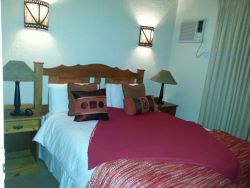 Second bedroom with queen bed. Airconditioner, ceiling fan and bathroom with shower, toilet and basin.