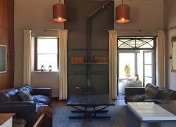 spacious lounge with wood-burning fireplace and double doors onto covered verandah