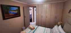 Main bedroom with queen size bed and built-in cupboards