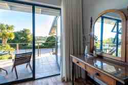 Main bedroom open onto private lagoon facing balcony with table and chairs